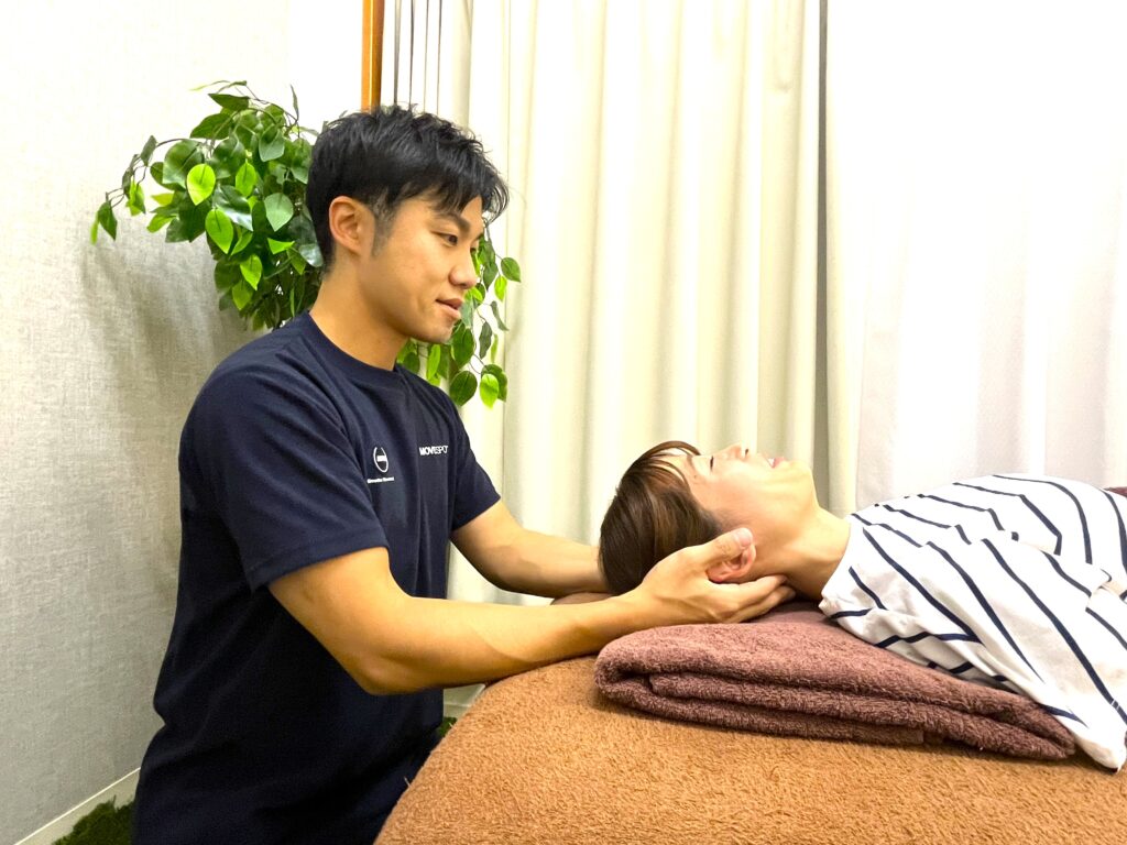 施術室で首まわりを丁寧に確認している様子