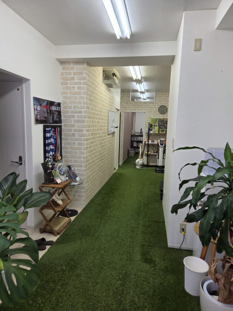 床全体に人工芝を敷いた院内の通路と観葉植物